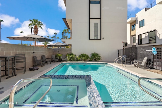 view of swimming pool featuring a community hot tub and a patio area