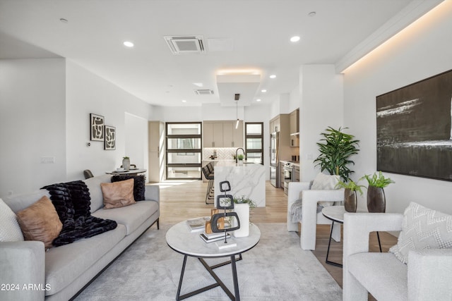 living room featuring light hardwood / wood-style floors and sink