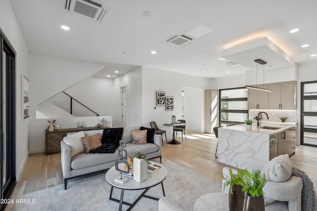 living room with light hardwood / wood-style floors and sink