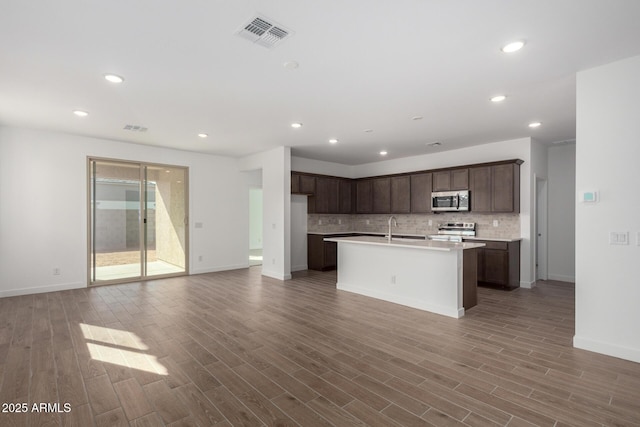 kitchen with hardwood / wood-style flooring, appliances with stainless steel finishes, sink, and decorative backsplash