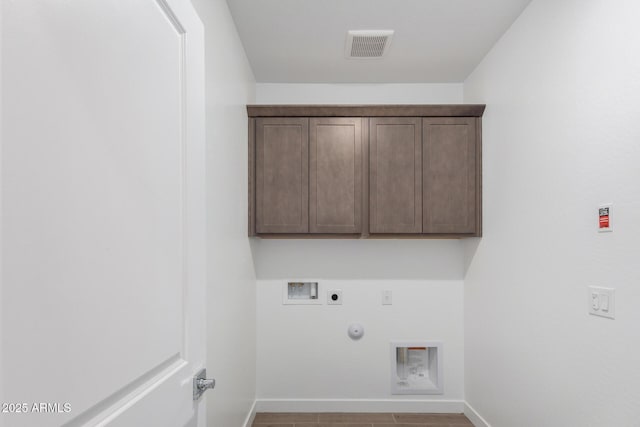 washroom with gas dryer hookup, heating unit, cabinets, hookup for a washing machine, and electric dryer hookup