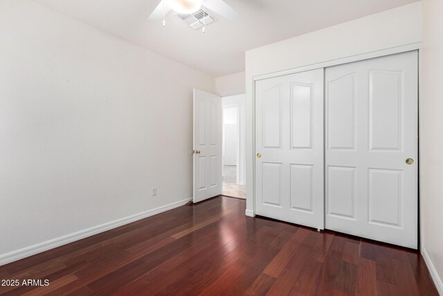 unfurnished bedroom featuring dark hardwood / wood-style flooring, a closet, and ceiling fan