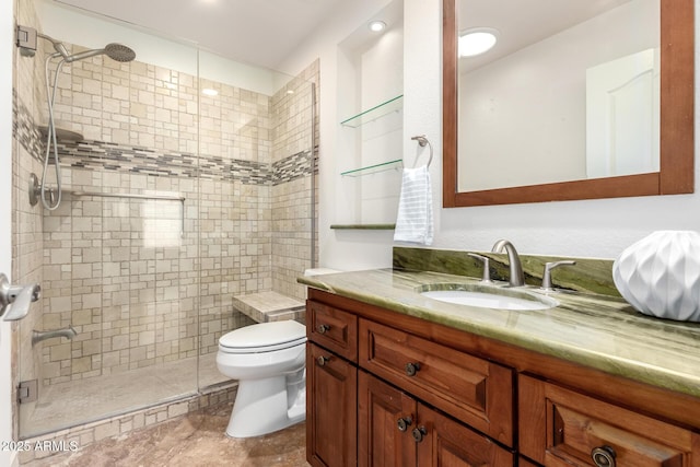 bathroom featuring vanity, a shower with shower door, and toilet