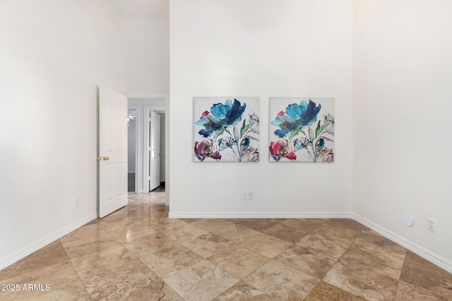 unfurnished room featuring a towering ceiling