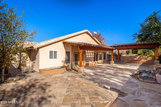 back of house with a pergola and a patio area