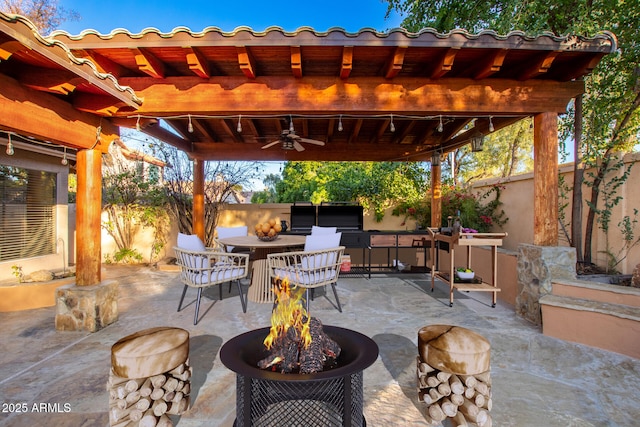 view of patio / terrace featuring ceiling fan and a fire pit