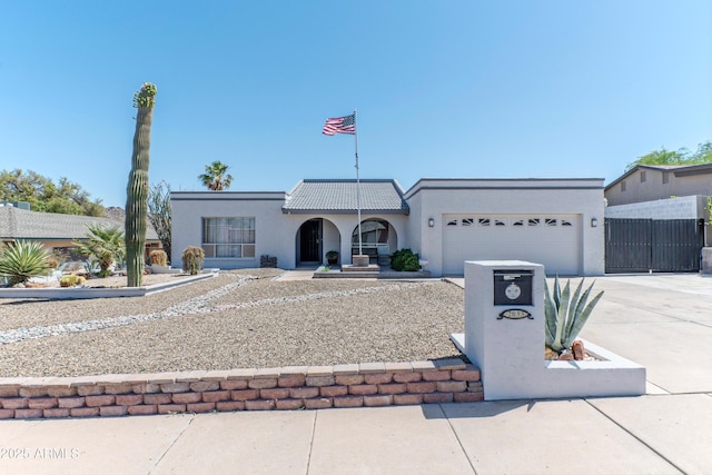 view of front of home with a garage, driveway, stucco siding, a tile roof, and fence
