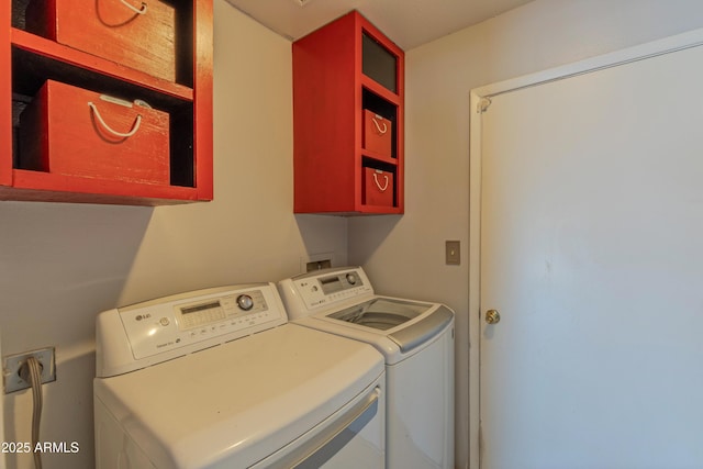 laundry area featuring washer and clothes dryer and cabinet space