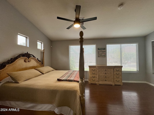 bedroom with lofted ceiling, multiple windows, dark wood-style flooring, and baseboards