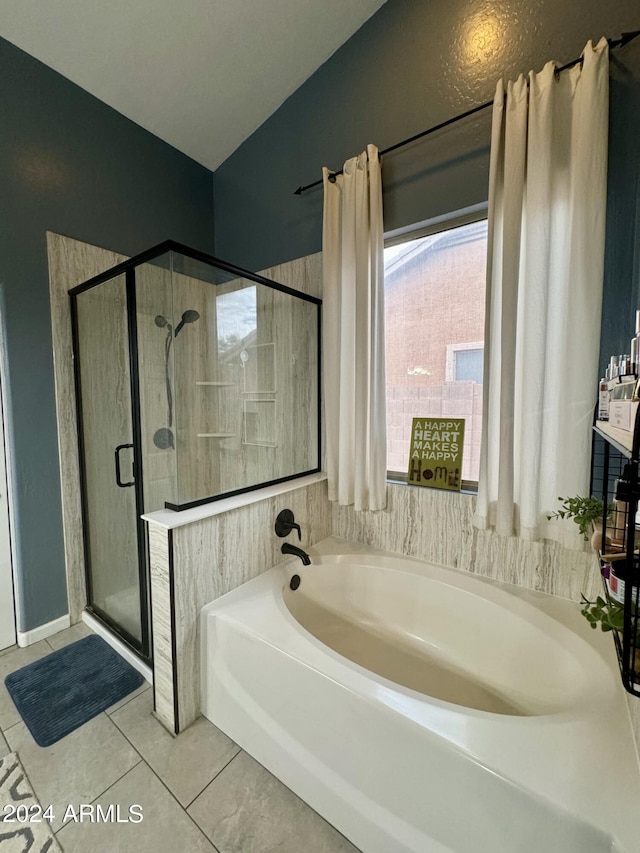 bathroom with a shower stall, a bath, and tile patterned floors