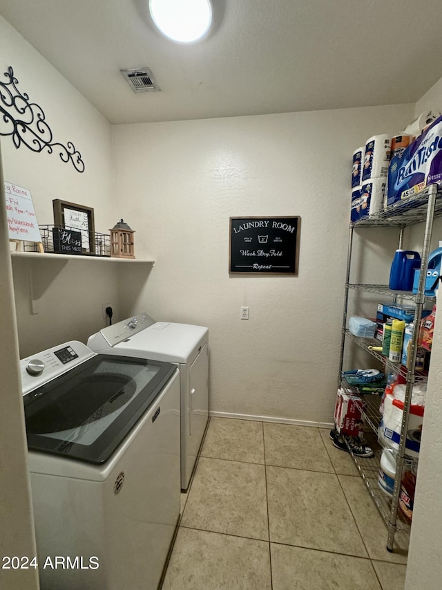 washroom with washing machine and dryer, laundry area, visible vents, and tile patterned flooring