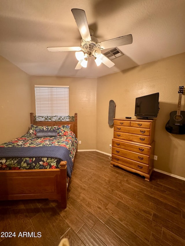 bedroom featuring baseboards, visible vents, ceiling fan, and wood finished floors