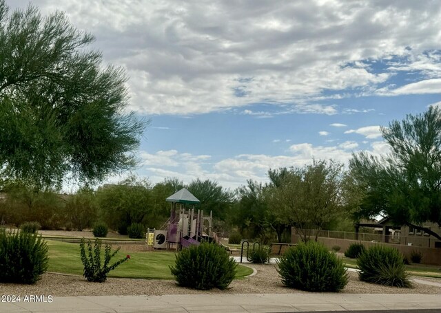 community play area featuring a yard and fence