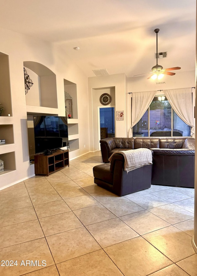 living area with a ceiling fan, visible vents, vaulted ceiling, built in features, and tile patterned floors