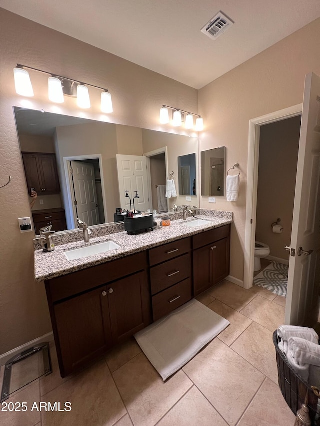 bathroom with vanity, tile patterned floors, and toilet