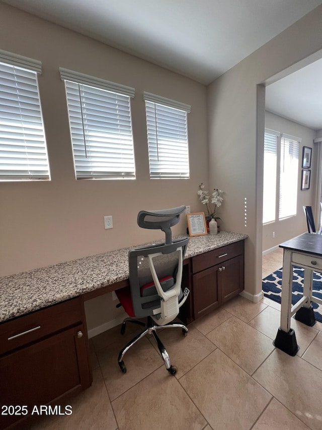 home office with light tile patterned flooring and built in desk