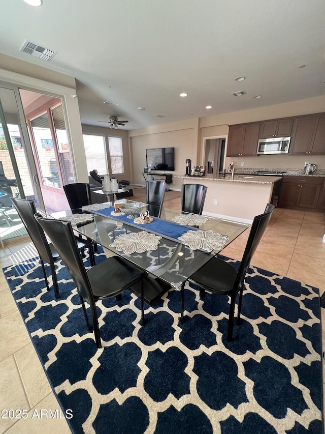 tiled dining area featuring ceiling fan