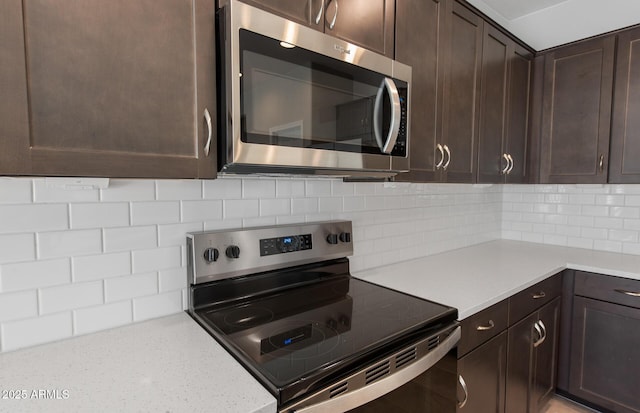 kitchen featuring decorative backsplash, dark brown cabinets, and stainless steel appliances