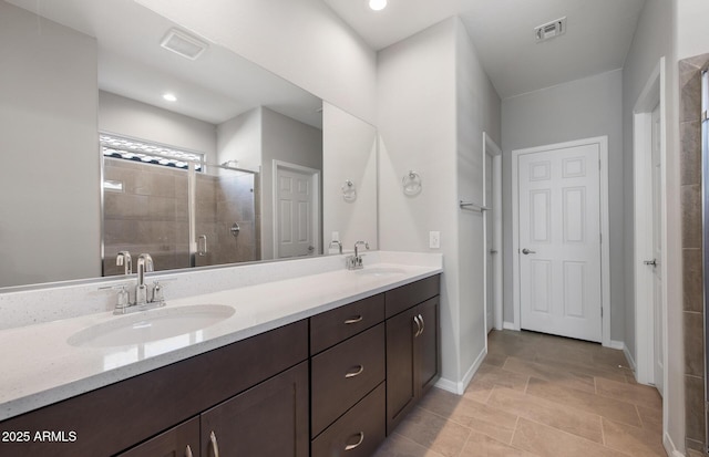 bathroom with a shower with door and vanity