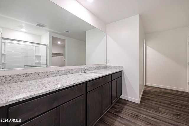 bathroom featuring hardwood / wood-style floors, a shower with door, and vanity