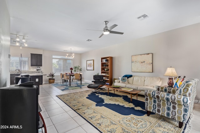 tiled living room featuring ceiling fan with notable chandelier