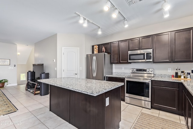 kitchen featuring light tile patterned floors, a center island, stainless steel appliances, and rail lighting