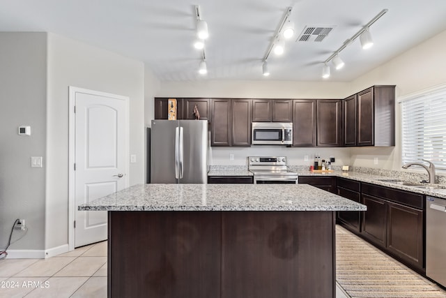 kitchen featuring rail lighting, a center island, appliances with stainless steel finishes, and sink