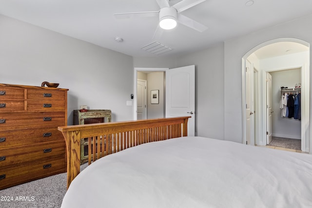 bedroom with light carpet, connected bathroom, a closet, and ceiling fan