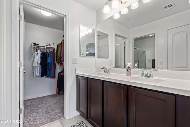 bathroom with tile patterned flooring, vanity, and an enclosed shower