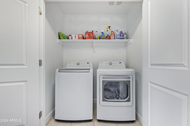 clothes washing area with independent washer and dryer and light tile patterned floors