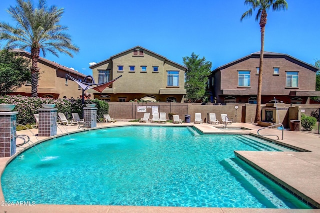 view of pool with central air condition unit, a patio area, and pool water feature