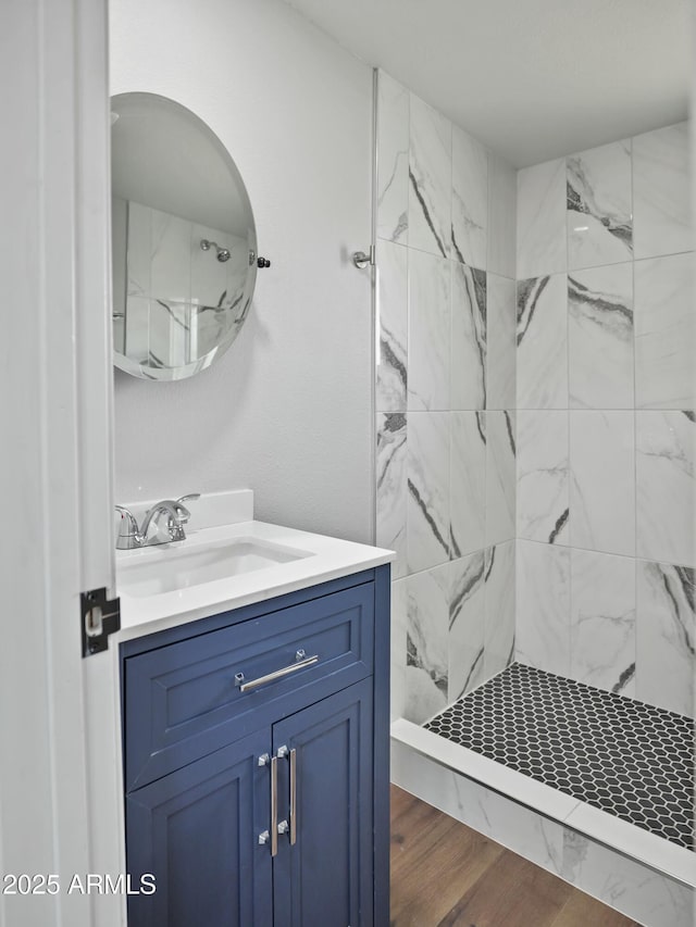 bathroom featuring vanity, hardwood / wood-style floors, and tiled shower