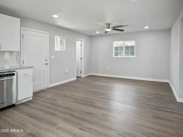 interior space with white cabinetry, stainless steel dishwasher, ceiling fan, and light hardwood / wood-style floors