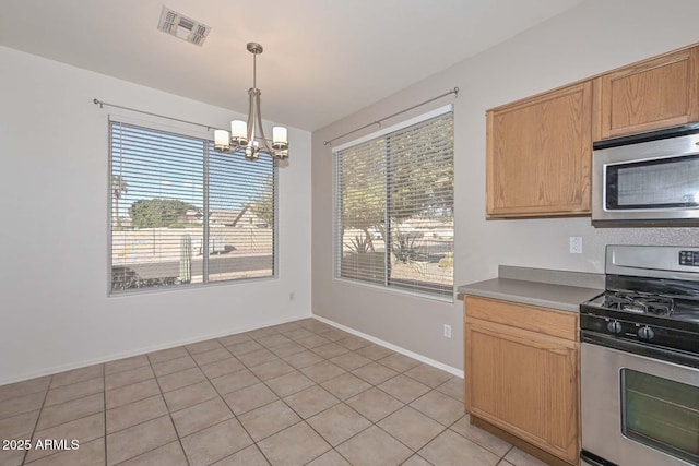 kitchen featuring light brown cabinetry, decorative light fixtures, a chandelier, light tile patterned floors, and stainless steel appliances