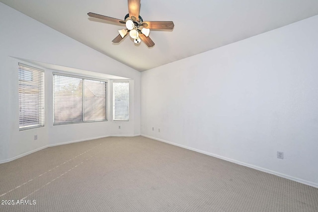 carpeted spare room with ceiling fan and lofted ceiling