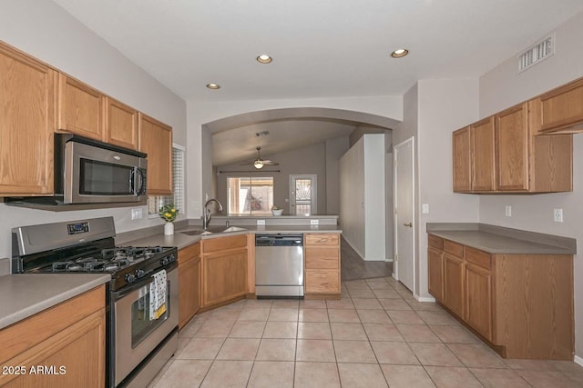 kitchen with light tile patterned flooring, sink, vaulted ceiling, ceiling fan, and stainless steel appliances