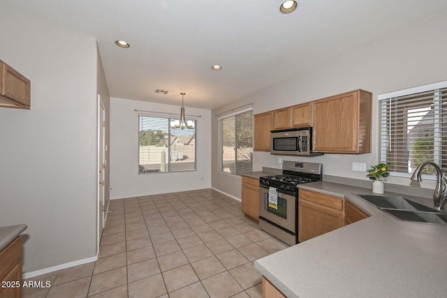 kitchen featuring sink, appliances with stainless steel finishes, light tile patterned flooring, decorative light fixtures, and a chandelier