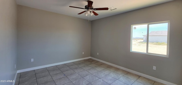 tiled spare room featuring ceiling fan