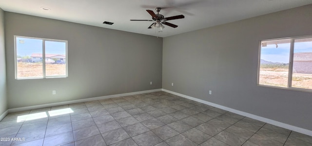 spare room featuring plenty of natural light, tile flooring, and ceiling fan