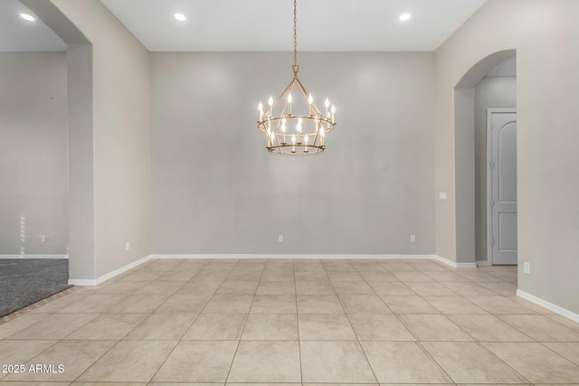 tiled empty room featuring a notable chandelier