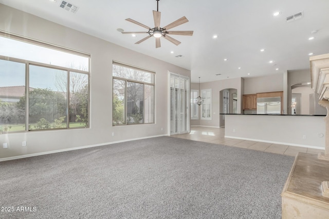 unfurnished living room featuring light tile patterned floors and ceiling fan