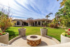 back of house featuring a patio, a fire pit, and a lawn