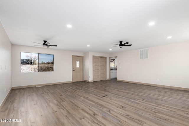 48451 N 27th Ave, New River, AZ 85087 - unfurnished living room featuring ceiling fan, light wood-style flooring, recessed lighting, and baseboards