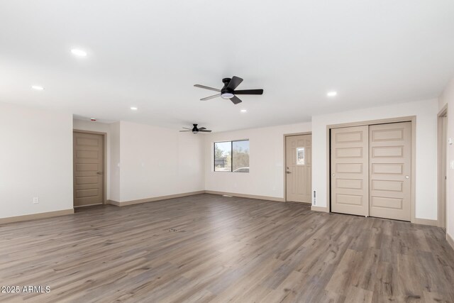 48451 N 27th Ave, New River, AZ 85087 - unfurnished living room featuring ceiling fan, recessed lighting, wood finished floors, and baseboards