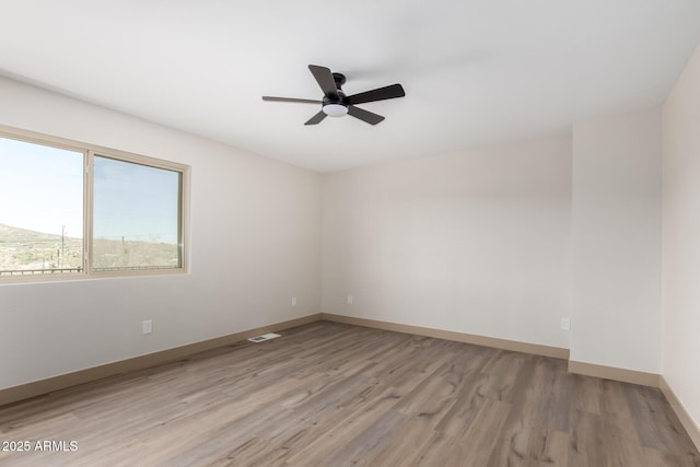 48451 N 27th Ave, New River, AZ 85087 - unfurnished room featuring light wood-style flooring, a ceiling fan, and baseboards