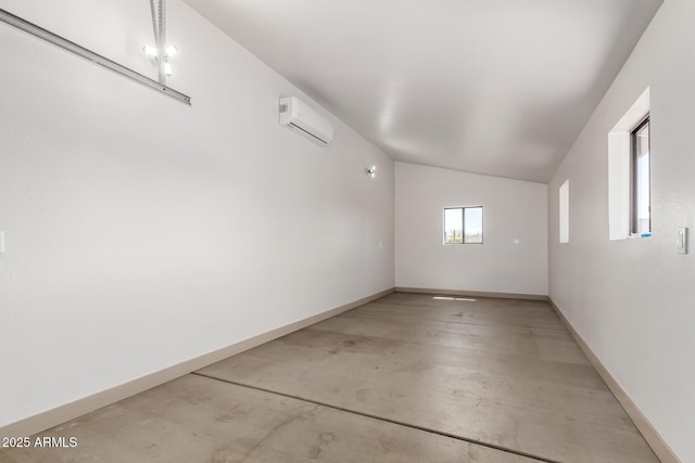 48451 N 27th Ave, New River, AZ 85087 - unfurnished room featuring concrete floors, an AC wall unit, lofted ceiling, and baseboards