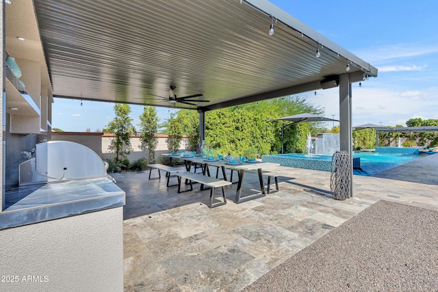 2652 E Pelican Ct, Gilbert, AZ 85297 - fenced backyard with outdoor dining space, a patio area, an outdoor kitchen, a ceiling fan, and a pool with connected hot tub