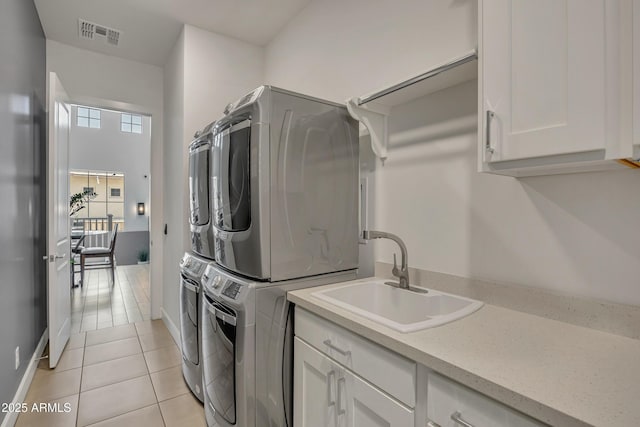 2652 E Pelican Ct, Gilbert, AZ 85297 - laundry room with stacked washing machine and dryer, cabinet space, and light tile patterned floors