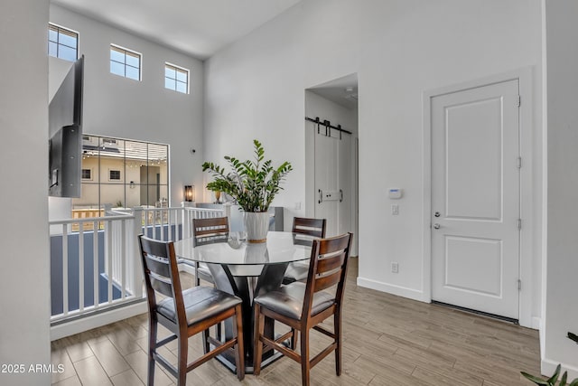 2652 E Pelican Ct, Gilbert, AZ 85297 - dining room with a barn door, a high ceiling, and wood finished floors