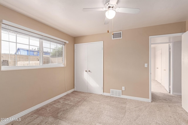 unfurnished bedroom with ceiling fan, a closet, and light carpet